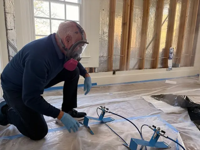 A restoration technician setting drying equipment in a El Cajon home stripped to the studs